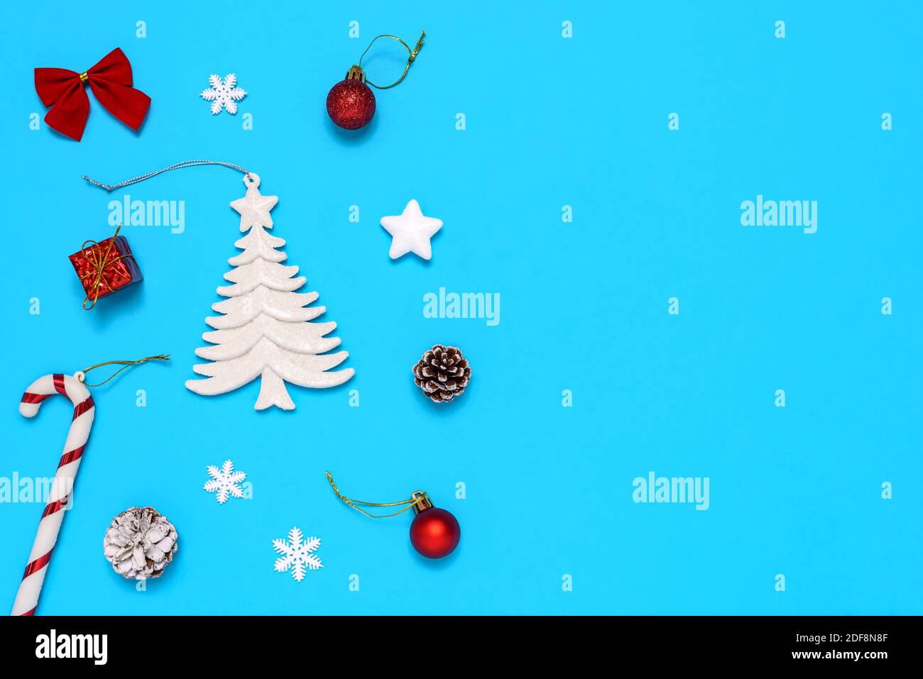 Sapin de Noël, cônes de pin, boîte-cadeau et décorations de Noël décoratives sur fond bleu. Le concept de célébrer le nouvel an et Noël. Banque D'Images