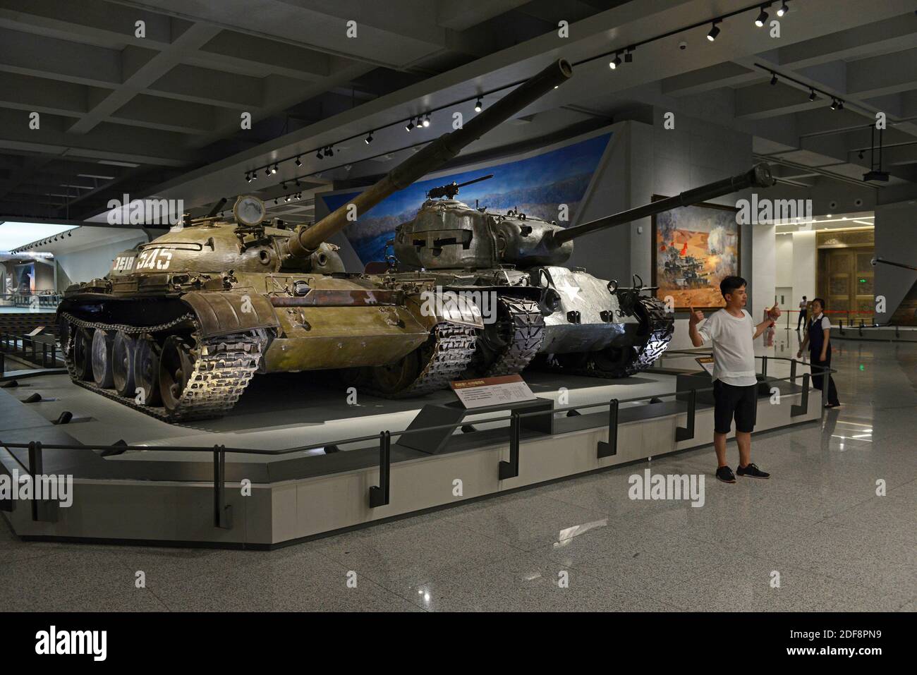 Le char soviétique T62, l'appareil photo le plus proche, exposé au musée militaire national de Beijing, en Chine, comme un visiteur pose pour une photographie Banque D'Images