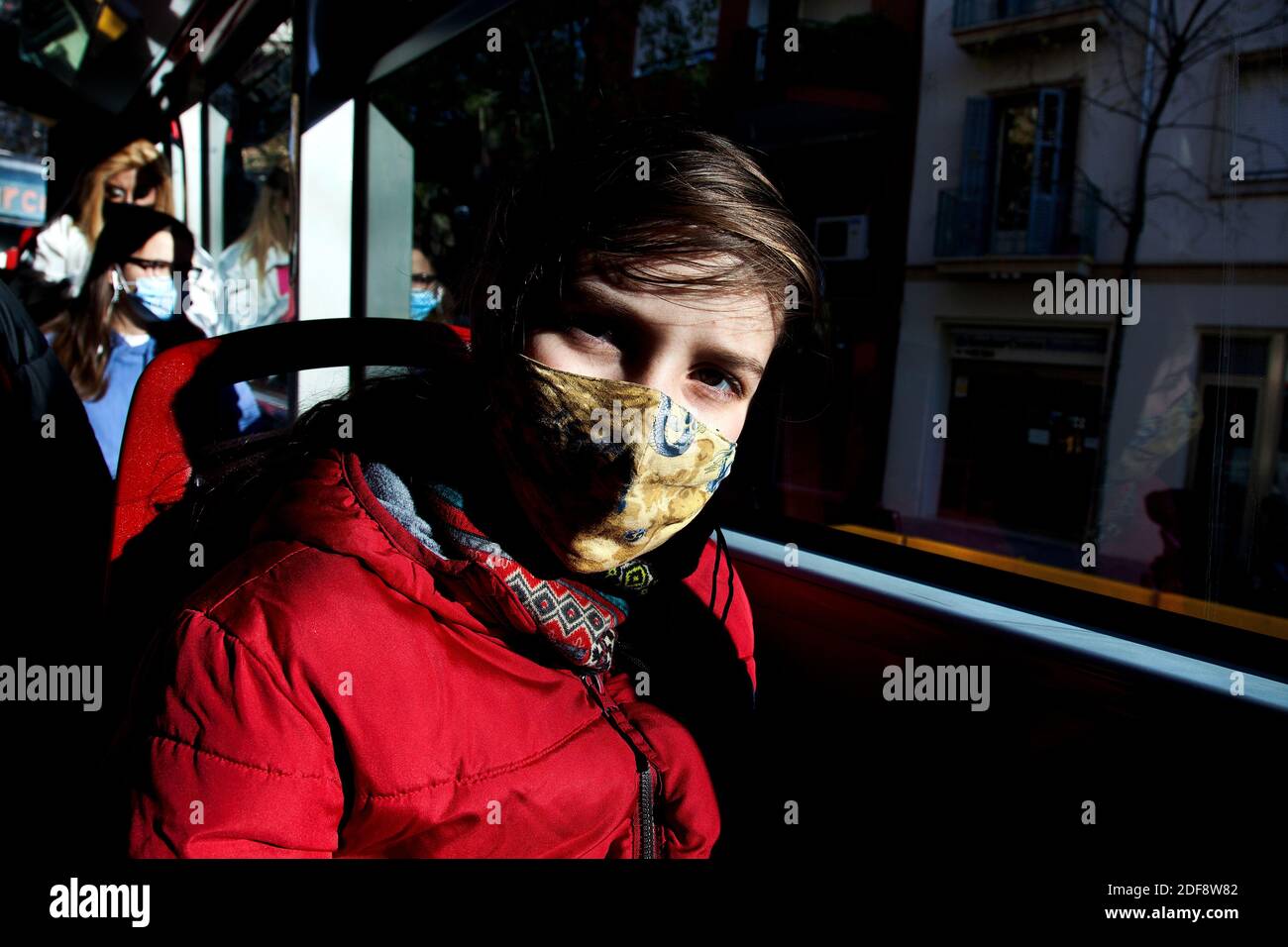 Garçon de 11 ans dans le bus portant un masque facial, Barcelone, Espagne. Banque D'Images
