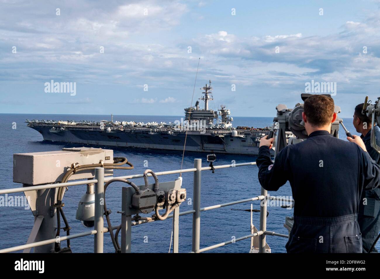 Document photo du dossier datée du 24 mars 2020 de marins à bord du navire d'assaut amphibie USS America (LHA 6), observez le porte-avions de classe Nimitz USS Theodore Roosevelt (CVN 71) en cours de formation en mer des Philippines. Brett Crozier, capitaine du porte-avions nucléaire Theodore Roosevelt, avec plus de 100 marins infectés par le coronavirus, a plaidé lundi auprès des responsables de la marine américaine pour des ressources permettant l'isolement de l'ensemble de son équipage et d'éviter d'éventuels décès dans une situation qu'il a décrite comme se détériorant rapidement. Photo par US Navy via ABACAPRESS.COM Banque D'Images