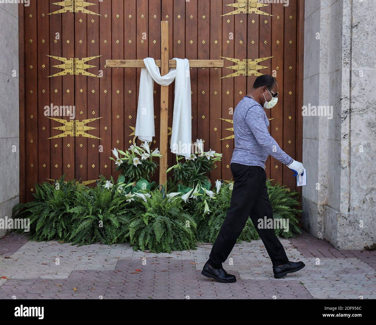 PAS DE FILM, PAS DE VIDÉO, PAS de télévision, PAS DE DOCUMENTAIRE - un homme non identifié passe les portes fermées de la cathédrale Sainte Marie alors que les lieux de culte ferment leurs portes, Mais télédiffusé leurs services de Pâques du dimanche via les médias sociaux, car les grands rassemblements sociaux et religieux sont interdits en raison des mandats d'hébergement en place par les gouvernements locaux et d'état le dimanche de Pâques, le 12 avril 2020 à Miami, FL, États-Unis. Photo de Carl Justa/Miami Herald/TNS/ABACAPRESS.COM Banque D'Images