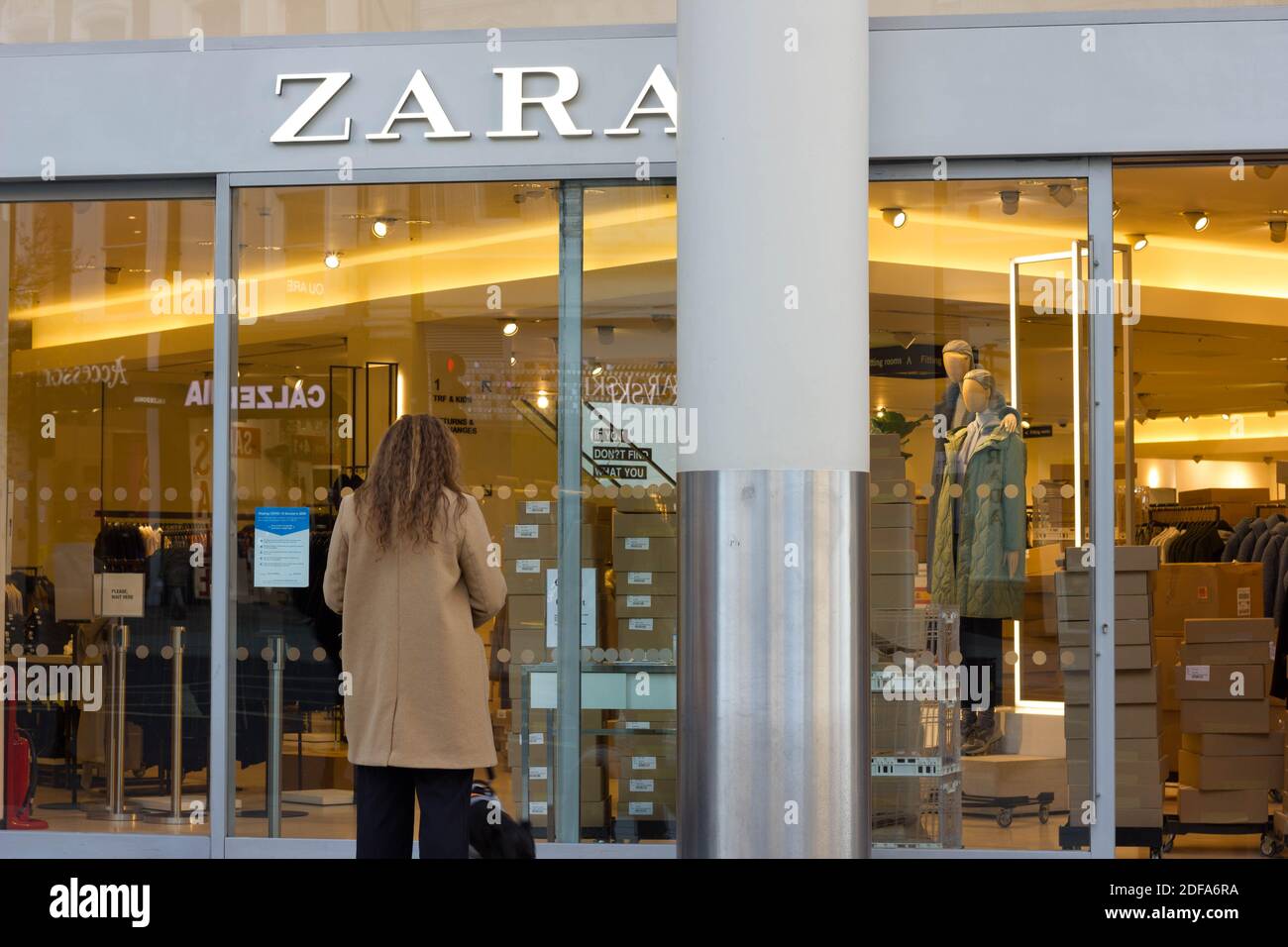 Les femmes en manteau avec un chien Window magasinent à l'extérieur DU MAGASIN DE mode ZARA sur oxford Street, Londres pendant que tous les magasins sont fermés, en Angleterre Banque D'Images