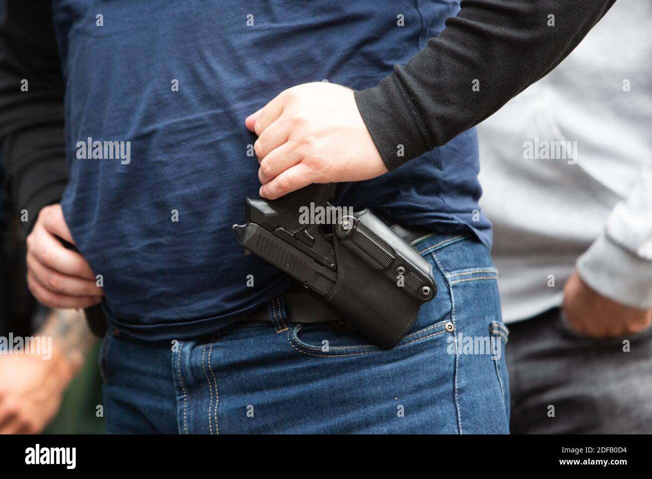 Les forces de police portent une arme SIG-Sauer Pro à la ceinture dans un  monde magique devant la Préfecture de police et le Palais de Justice à  Paris, France, le 17 2020