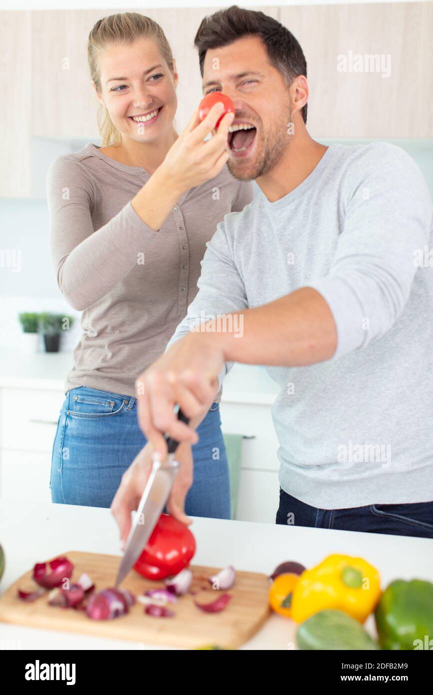 couple joueur s'amusant dans la cuisine - nez clown Banque D'Images