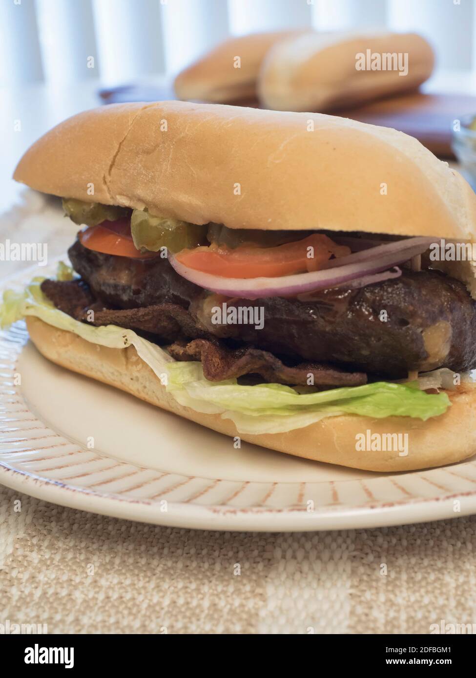 Cheeseburger farci sur un pain de cagoule accompagné de légumes et de bacon, également connu sous le nom de lucy juteuse Banque D'Images