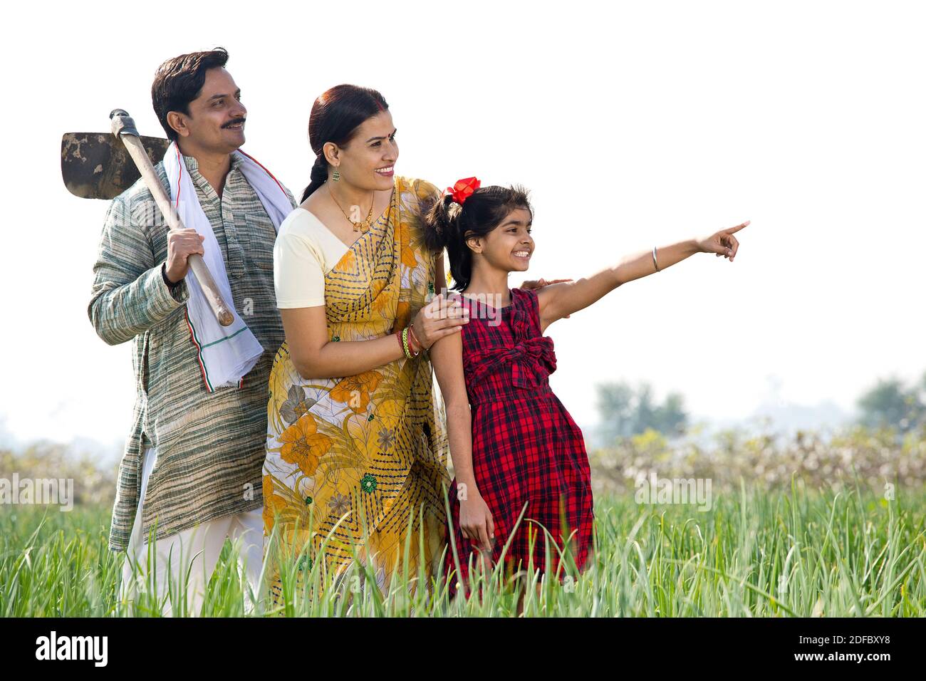 Famille indienne heureuse dans le champ agricole en regardant loin Banque D'Images