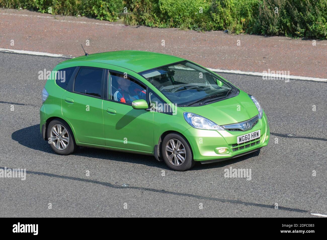 2011 vert Honda Jazz HS IMA CVT ; circulation automobile, véhicules en mouvement, voitures, véhicule roulant sur les routes du Royaume-Uni, moteurs, conduite sur l'autoroute M6 réseau routier du Royaume-Uni. Banque D'Images