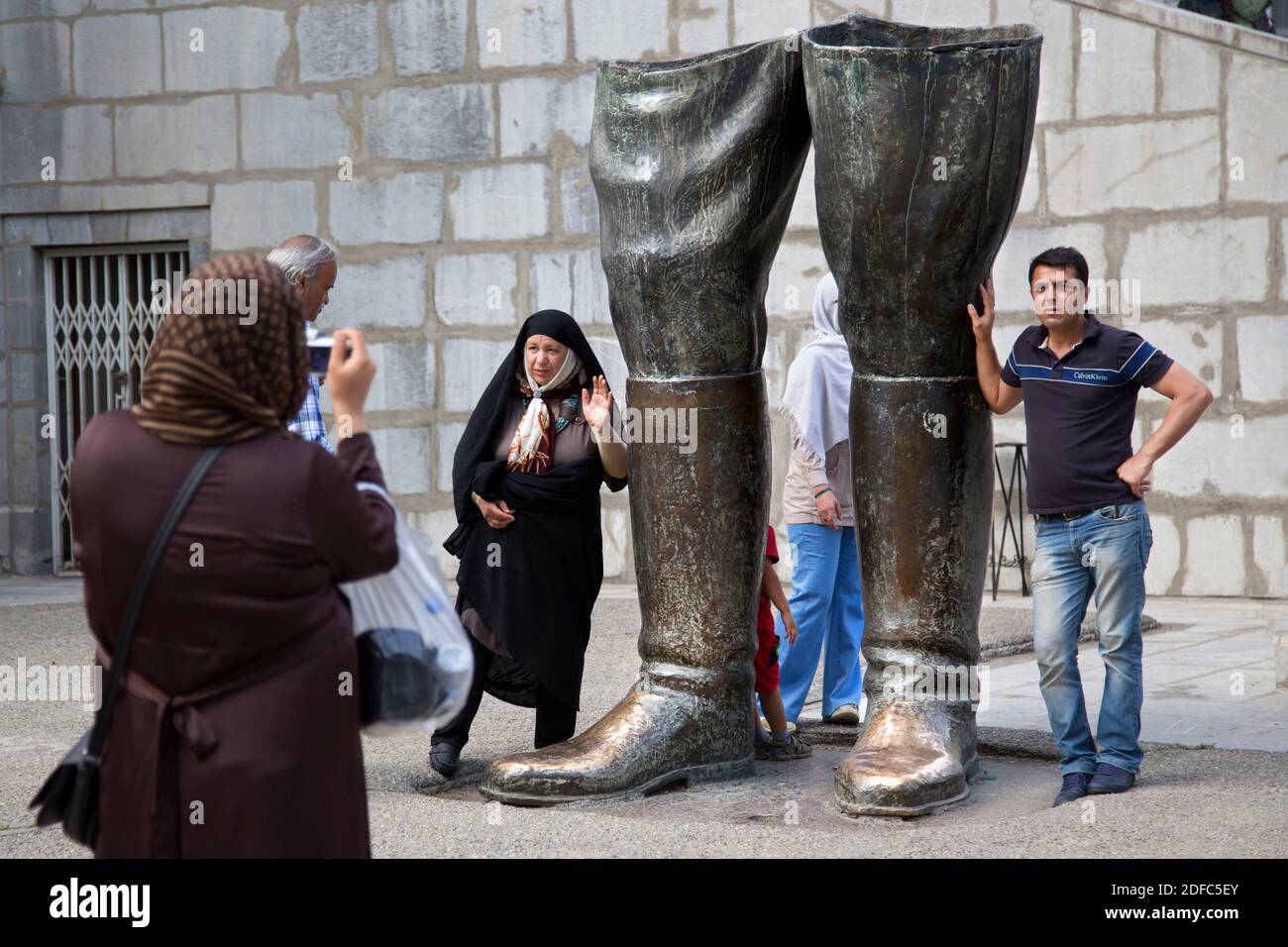 Iran, Téhéran, rue Valiasr, une famille iranienne pose à côté des bottes du Shah au complexe sa'd Abad Banque D'Images
