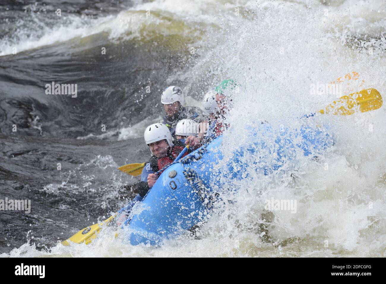 Les gens sur un radeau pneumatique qui fait le cheval sur les vagues. Banque D'Images