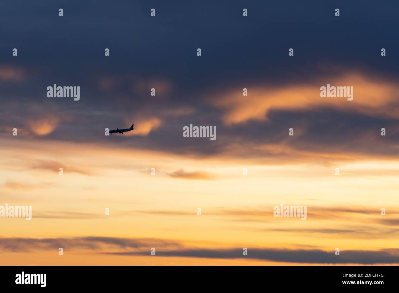 Avion volant dans le ciel brûlant de Laponie pendant le coucher du soleil arctique, Finlande Banque D'Images