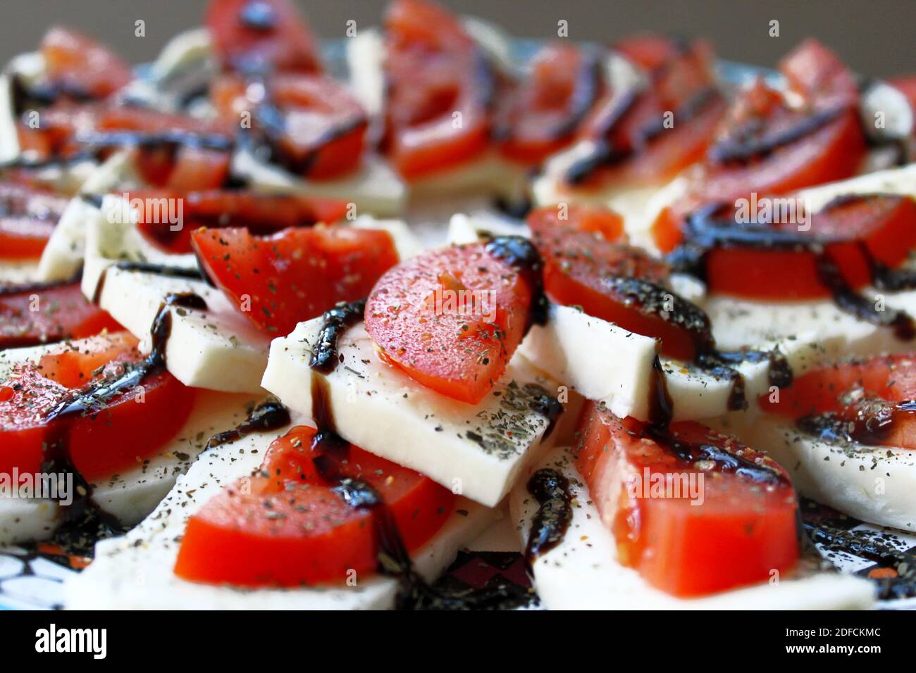 Salade Caprese avec tomates fraîches en tranches et fromage à la saumure sur le fond de l'assiette.Gros plan. Banque D'Images