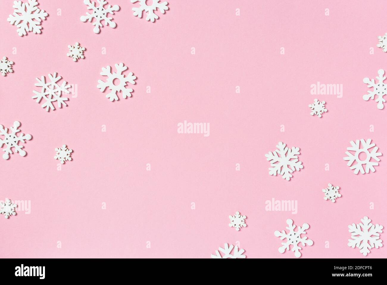 Composition de Noël en flocons de neige sur fond rose pastel. Concept d'hiver. Flat lay, vue de dessus, espace de copie. Banque D'Images