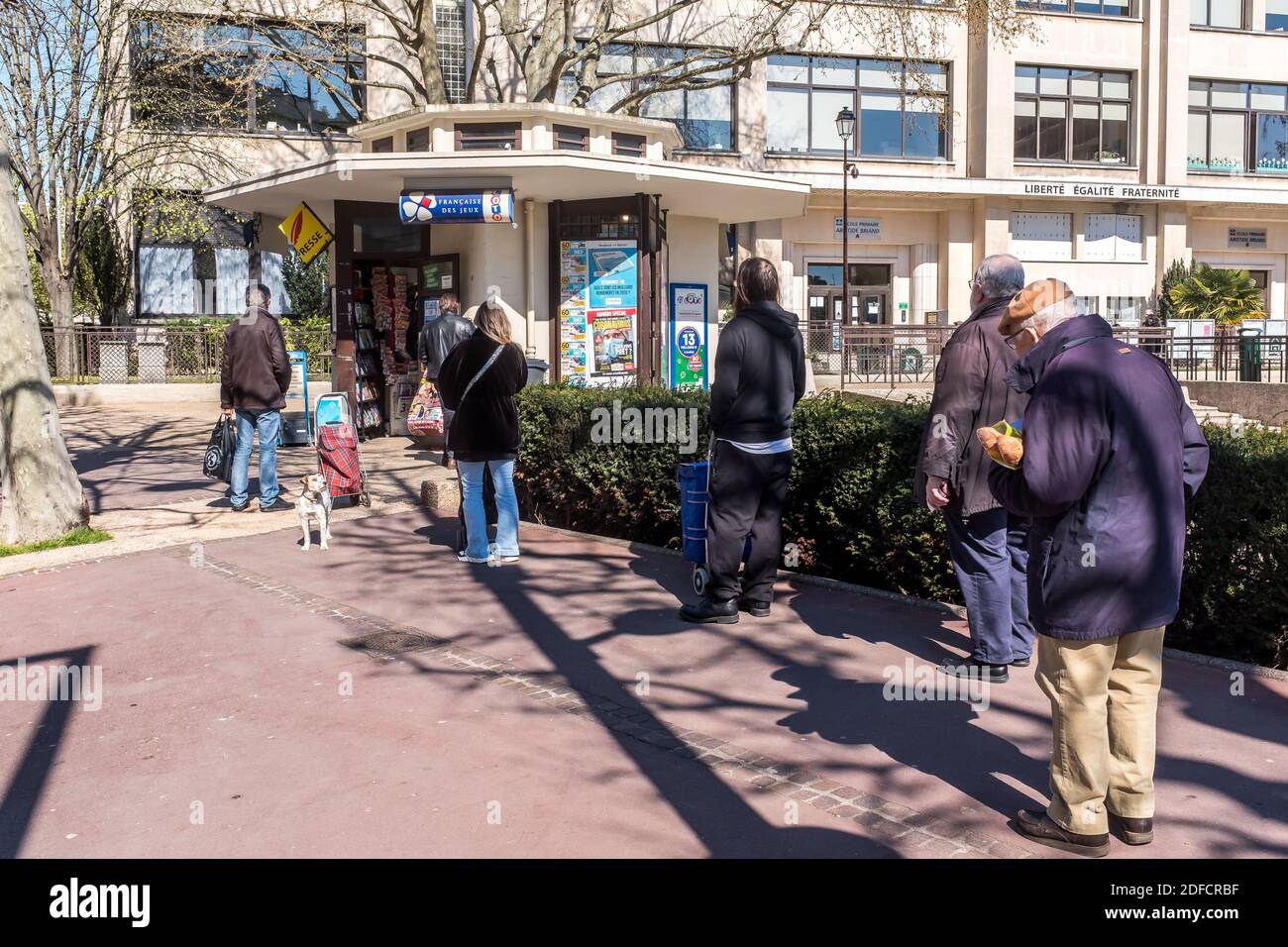 LIGNE D'ATTENTE DEVANT UN KIOSQUE DE JOURNAUX, PERSONNES RESPECTANT LES DISTANCES DE SÉCURITÉ PENDANT LE CONFINEMENT PANDÉMIQUE COVID-19, PARIS, ILE DE FRANCE Banque D'Images