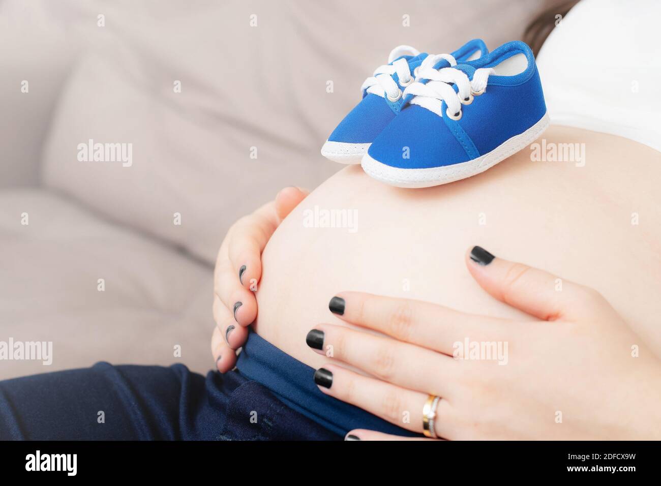 Chaussures De Bebe Sur Le Ventre D Une Femme Enceinte C Est Un Garcon Maman Tenant Le Ventre Photo Stock Alamy