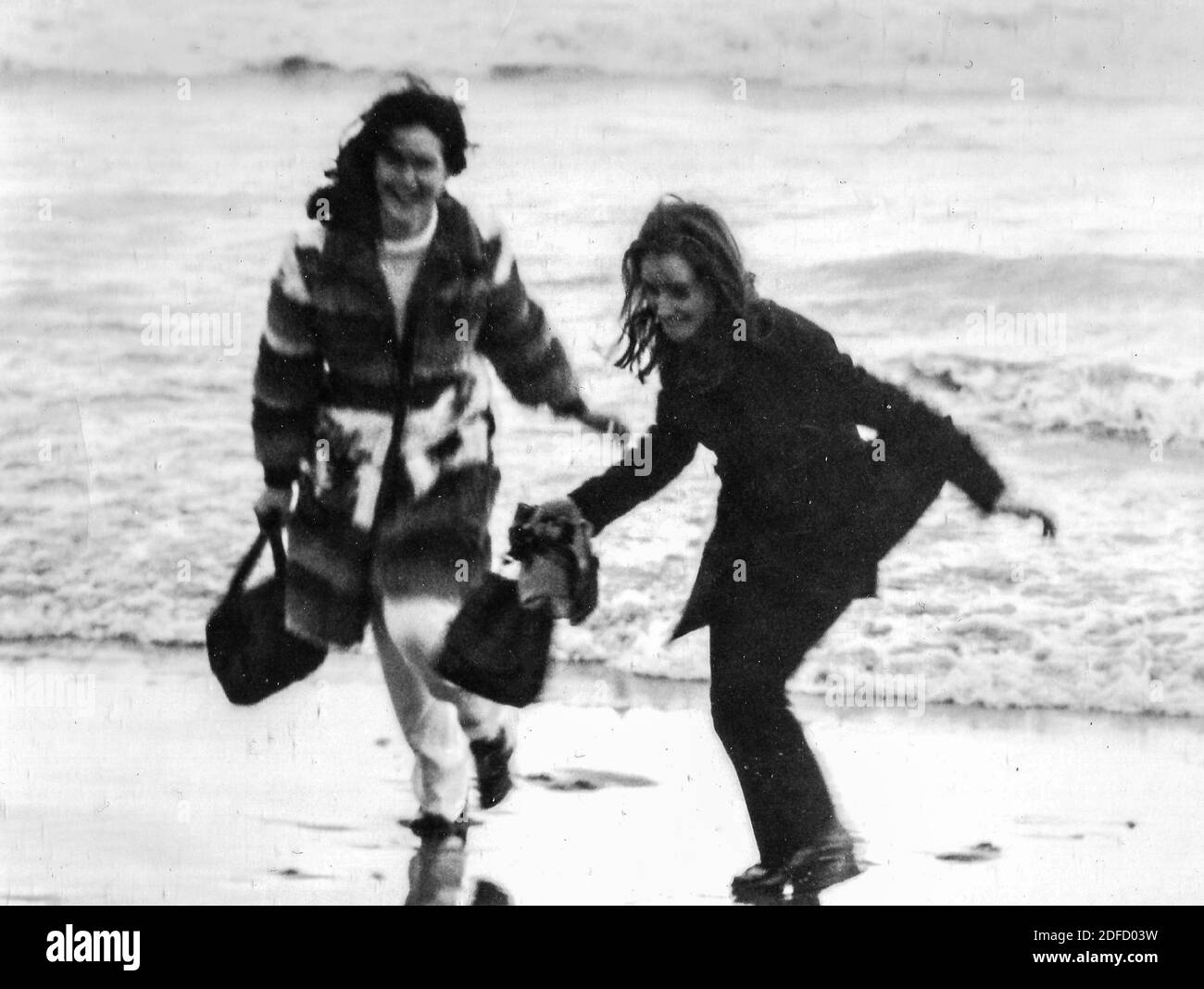 Années 1960, années 1970 jeunes amis de la mer en plein air en noir et blanc s'amuser sur la plage de Castinglioncello en Toscane. Italie. Numérisation des rayures et des imperfections Banque D'Images