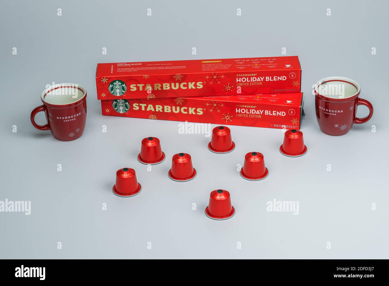 Tasses à espresso de Noël Starbucks à côté de la machine Nespresso. Variété  de tasses de vacances de marque derrière des capsules d'aluminium utilisées  pour faire du café goutte à goutte Photo