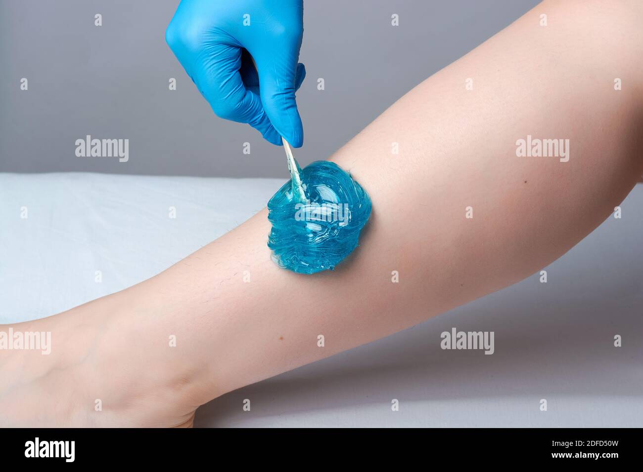 la procédure de bruissement des jambes.l'application du sucre bleu paste.depilation dans le salon Banque D'Images