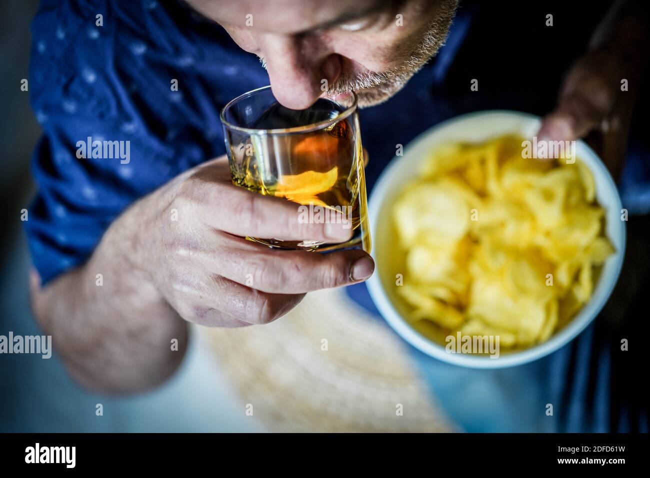 Homme mangeant des chips de pommes de terre. Banque D'Images