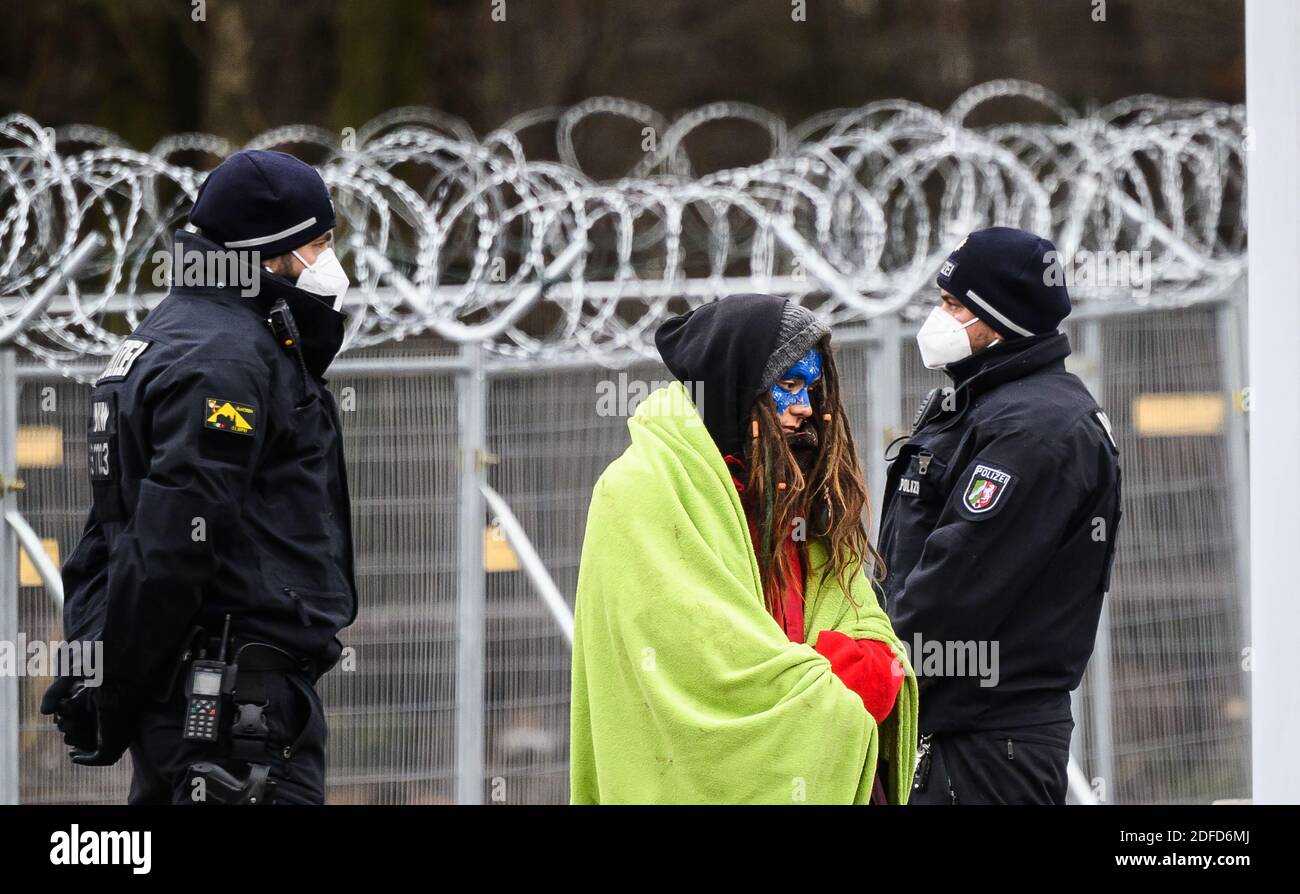 Dannenrod, Allemagne. 04e décembre 2020. Une militante se tient entre les policiers pendant qu'ils enregistrent ses détails personnels. Les écologistes continuent de protester à Dannenröder Forst contre les travaux de défrichement liés à la construction de l'A49 Autobahn. Une présence massive de la police accompagne le travail de compensation, qui pourrait être achevé dans les prochains jours. Credit: Andreas Arnold/dpa/Alay Live News Banque D'Images