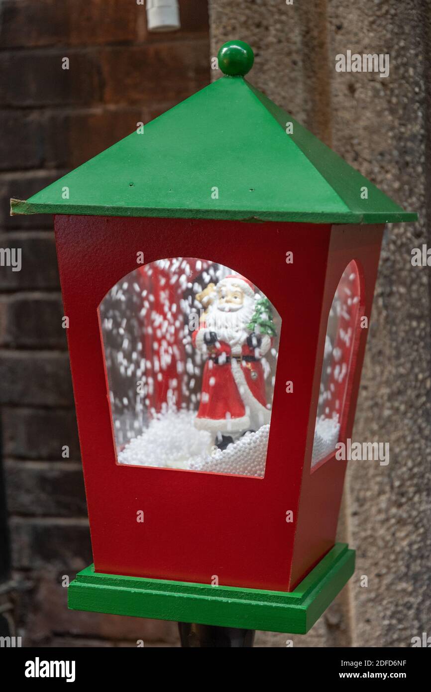Lanterne brillante décoration de Noël en gros plan. Jouet Père Noël dans une lanterne rétro en bois rouge et vert avec boule de neige à l'intérieur Banque D'Images