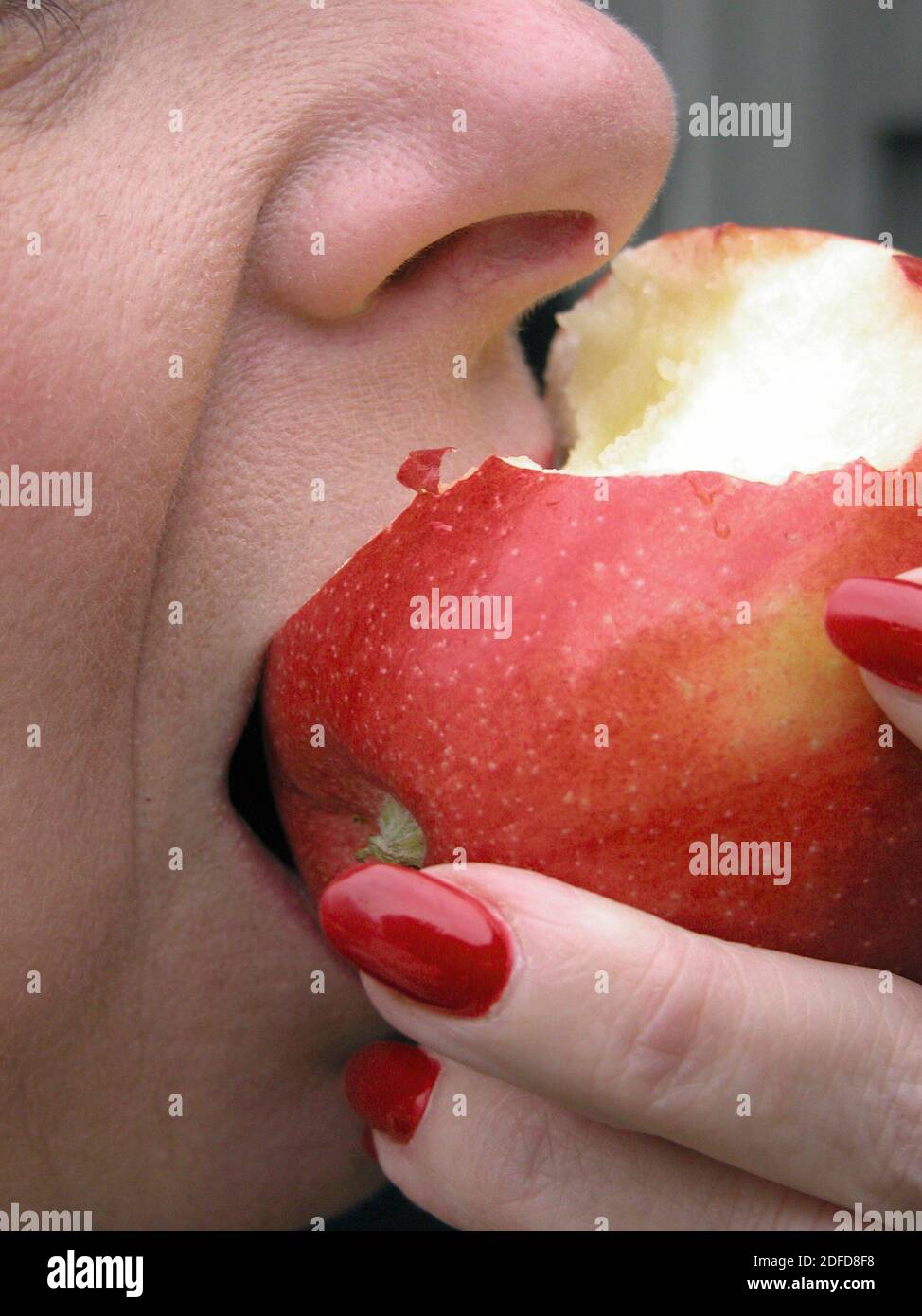 Femme prenant un morceau d'une pomme rouge délicieuse Banque D'Images