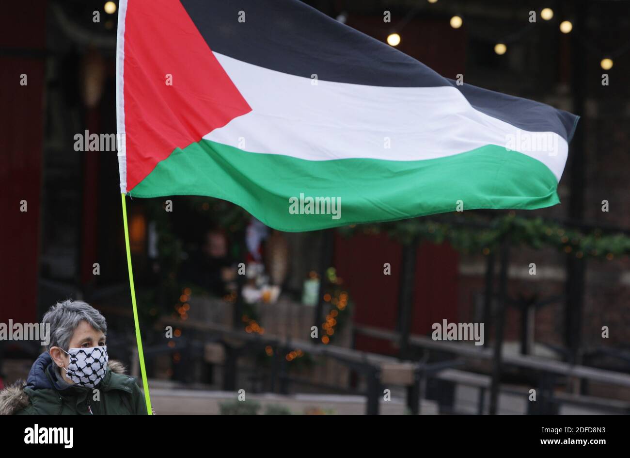 Amsterdam, pays-Bas. 04e décembre 2020. Un activiste néerlandais anti-guerre du ÔWomen à BlackÕ portant un masque facial protecteur tient un drapeau palestinien pendant la manifestation ÔIsrael Arrêtez l'occupation au Nieuwmarkt dans le contexte de la pandémie du coronavirus le 4 décembre 2020 à Amsterdam, pays-Bas. Les femmes en noir sont un réseau mondial de femmes engagées dans la paix avec justice et activement opposées à l'injustice, à la guerre, au militarisme et à d'autres formes de violence. (Photo de Paulo Amorim/Sipa USA) Credit: SIPA USA/Alay Live News Banque D'Images