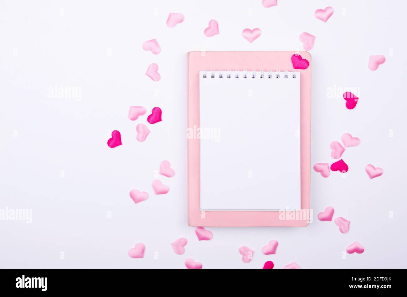 Carnet pour liste de souhaits avec coeurs roses sur fond blanc. Maquette. Banque D'Images