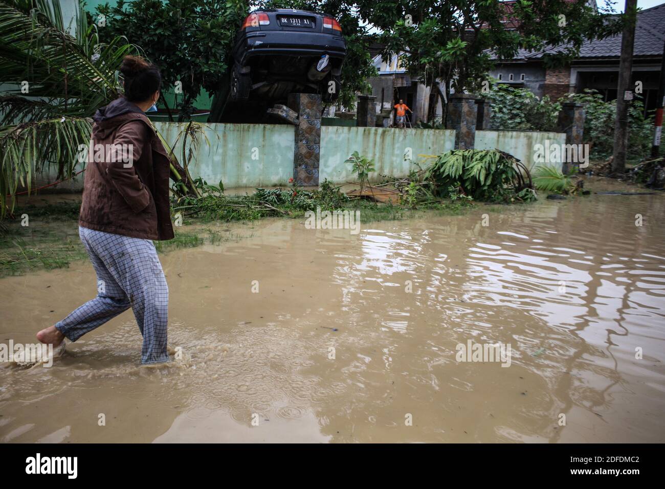 Un résident traverse une route submergée.plus de 12,338 résidents ont été touchés par les inondations provoquées par les pluies torrentielles et les rivières débordantes dont cinq décès ont été signalés. Banque D'Images
