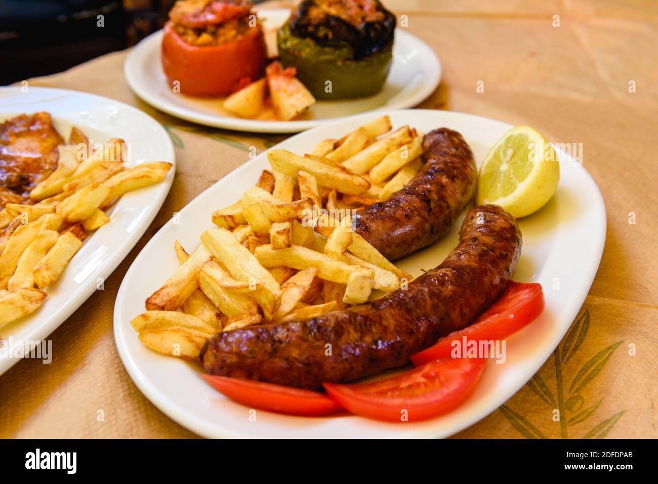 Saucisses grillées servies avec des frites sur l'assiette. Plat de restauration rapide typique Banque D'Images