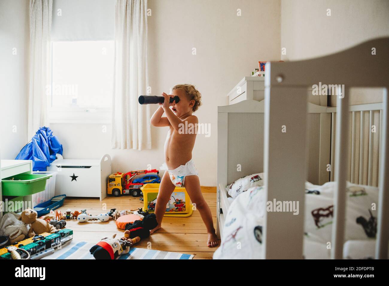 Enfant dans les couches jouant dans sa pièce désordonnée prétendant qu'il est un pirate Banque D'Images