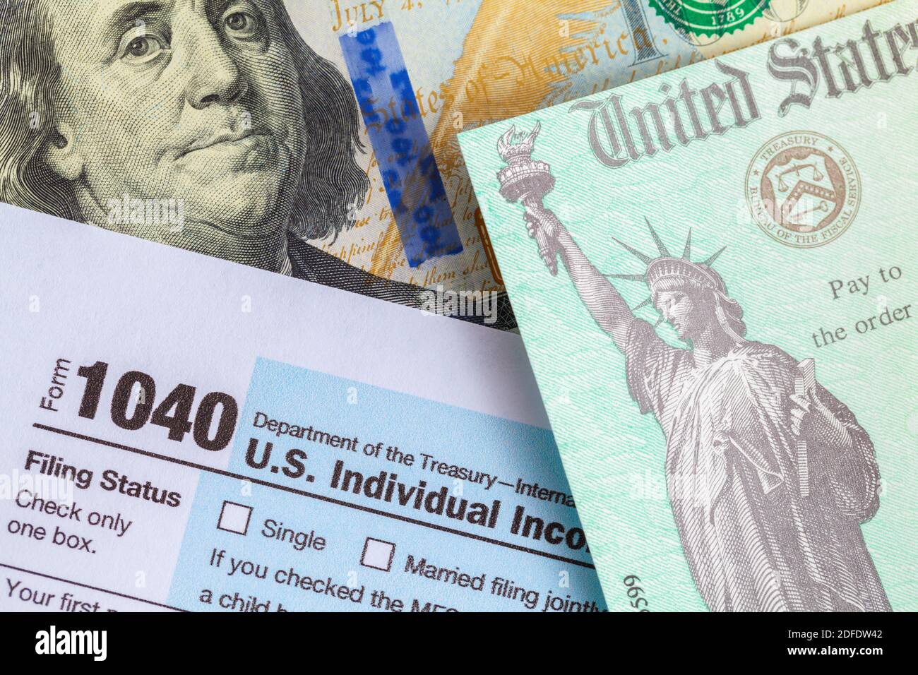 Chèque de remboursement d'impôt au-dessus du formulaire 1040 et d'une facture de cent dollars. Banque D'Images