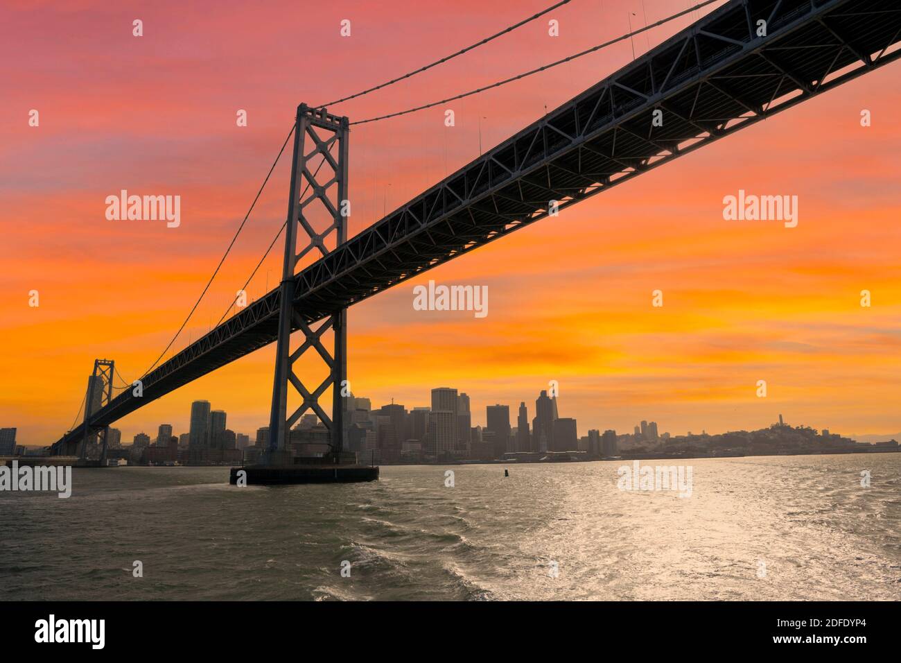 Vue sur le Bay Bridge au coucher du soleil entre San Francisco et Oakland California. Banque D'Images