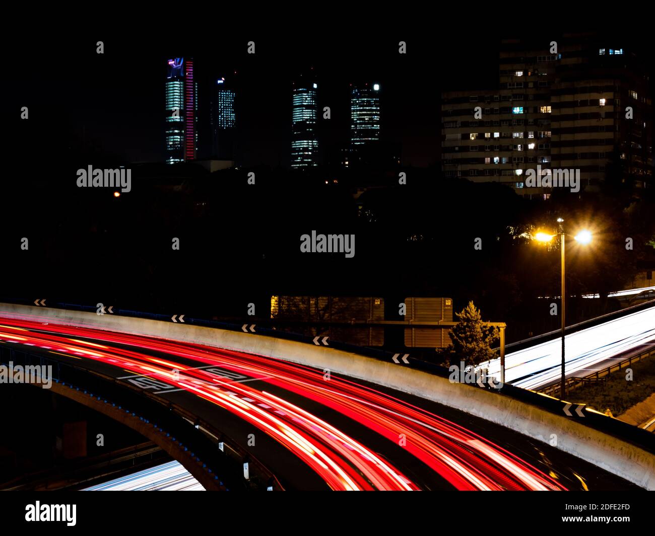 Traversée de sentiers lumineux causée par les feux de voiture la nuit Banque D'Images