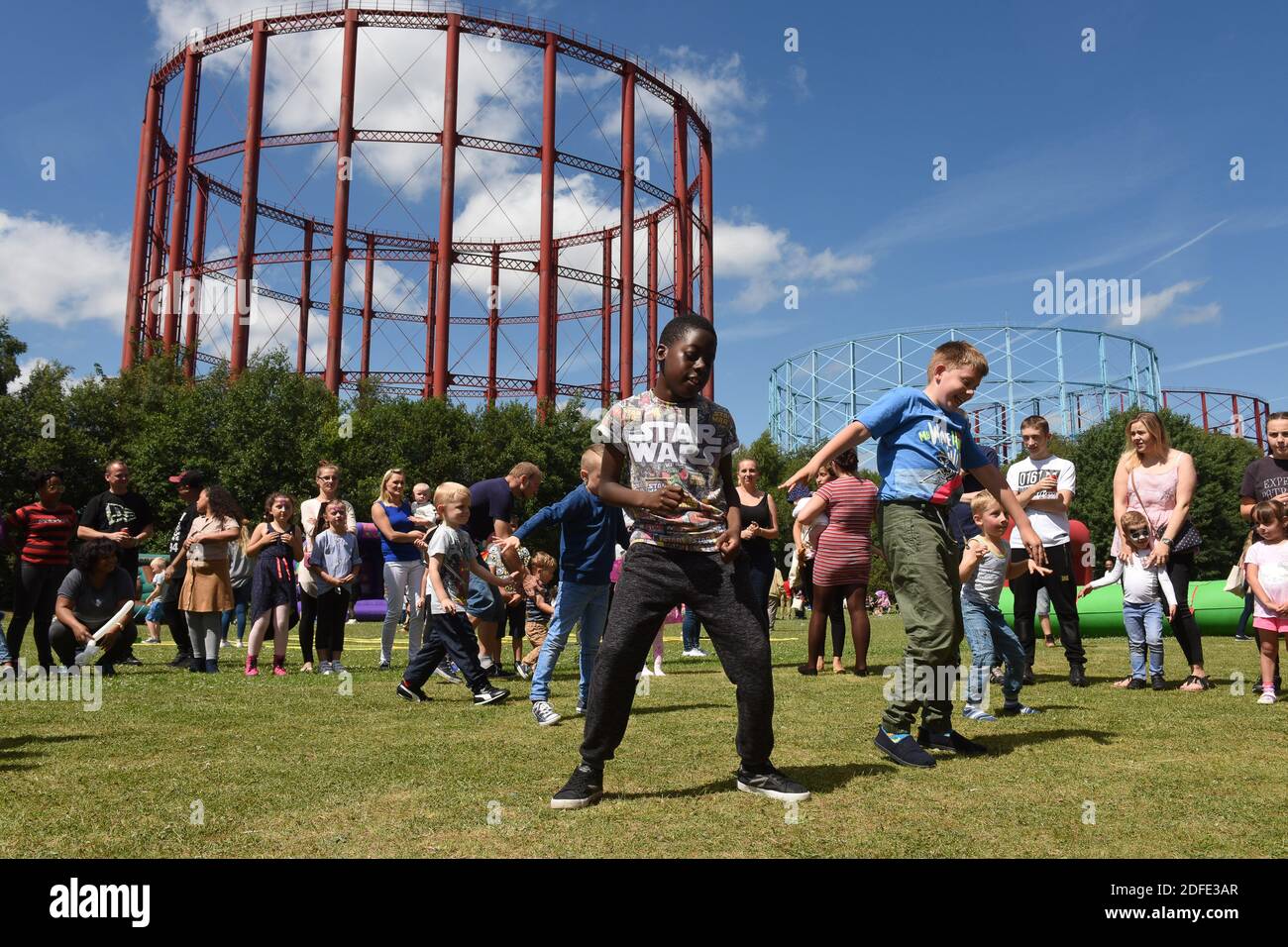 Enfants jouant dans le parc à côté des gazéomètres des propriétaires d'essence à Windsor Street Gas Works à Nechells, Birmingham Banque D'Images