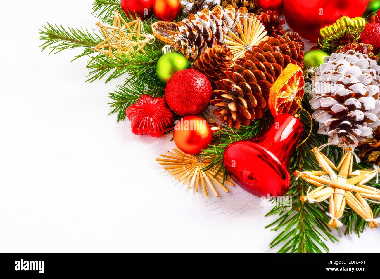 Décoration de Noël avec tranches d'orange séchées, cloche rouge et étoile de paille. Arrière-plan de Noël avec branches de sapin et cônes de pin. Copier sp Banque D'Images