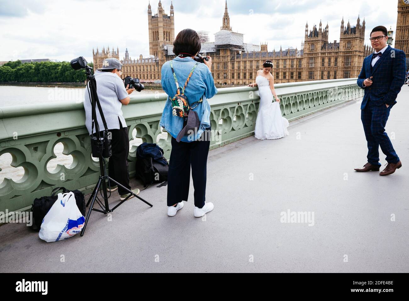 Séance photo à des jeunes asiatiques récemment mariés sur le pont de Westminster. Londres, Angleterre, Royaume-Uni, Europe Banque D'Images