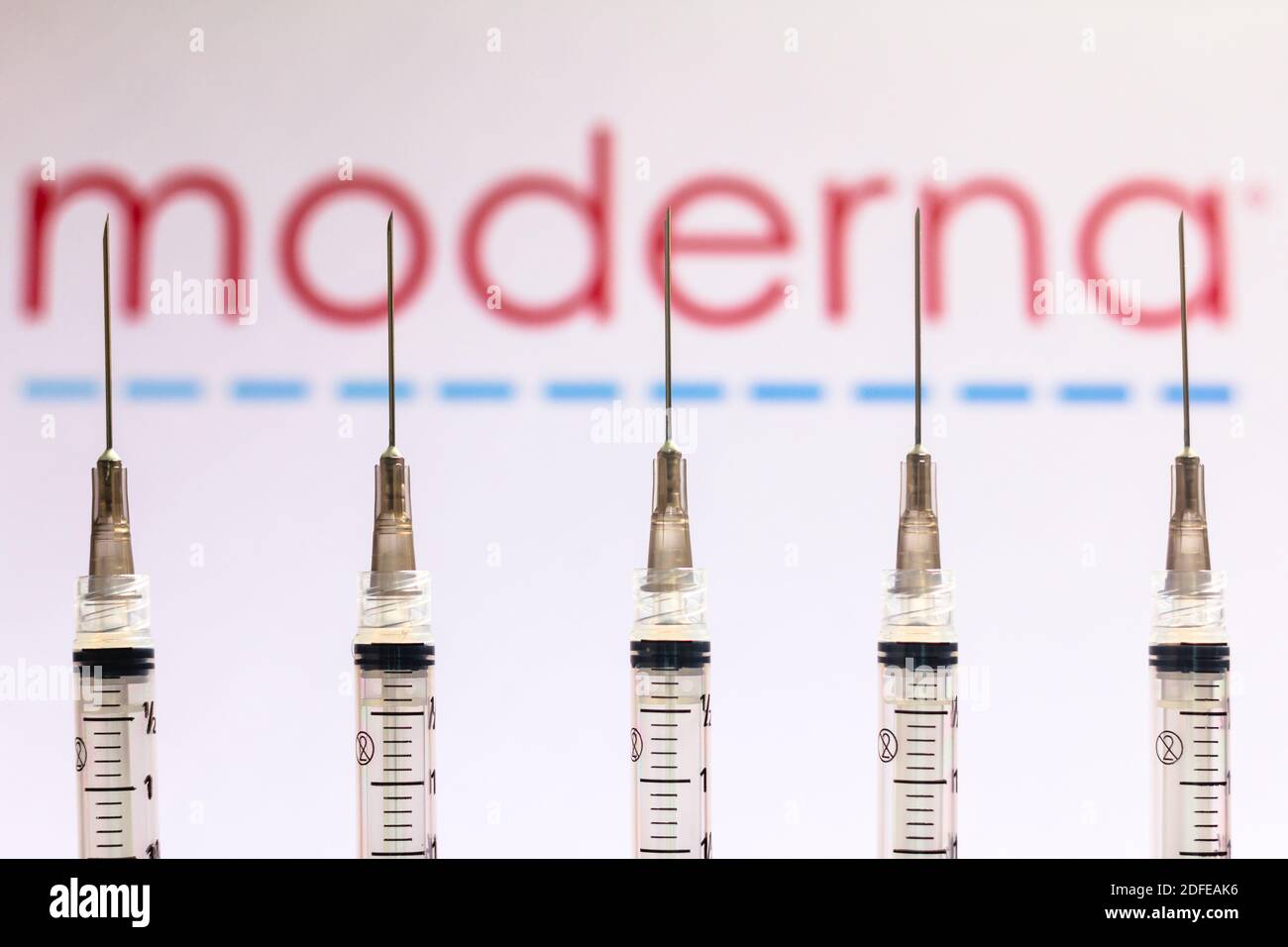 Dans cette photo illustration différentes seringues médicales vu avec le logo de la société Moderna Therapeutics affiché sur un écran en arrière-plan. Banque D'Images