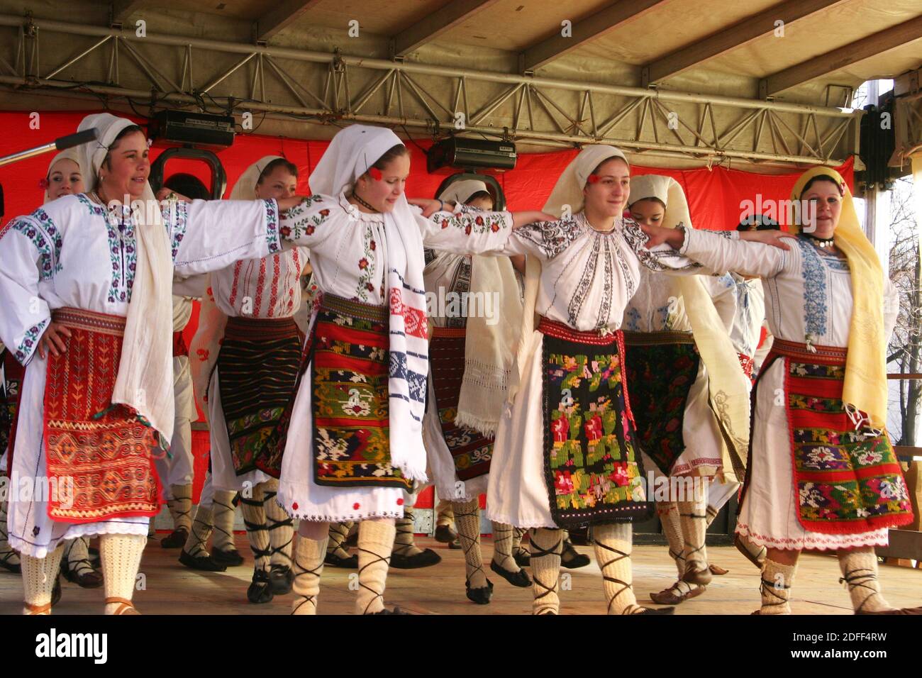 Groupe de femmes roumaines portant de magnifiques costumes traditionnels dansant une étape Banque D'Images