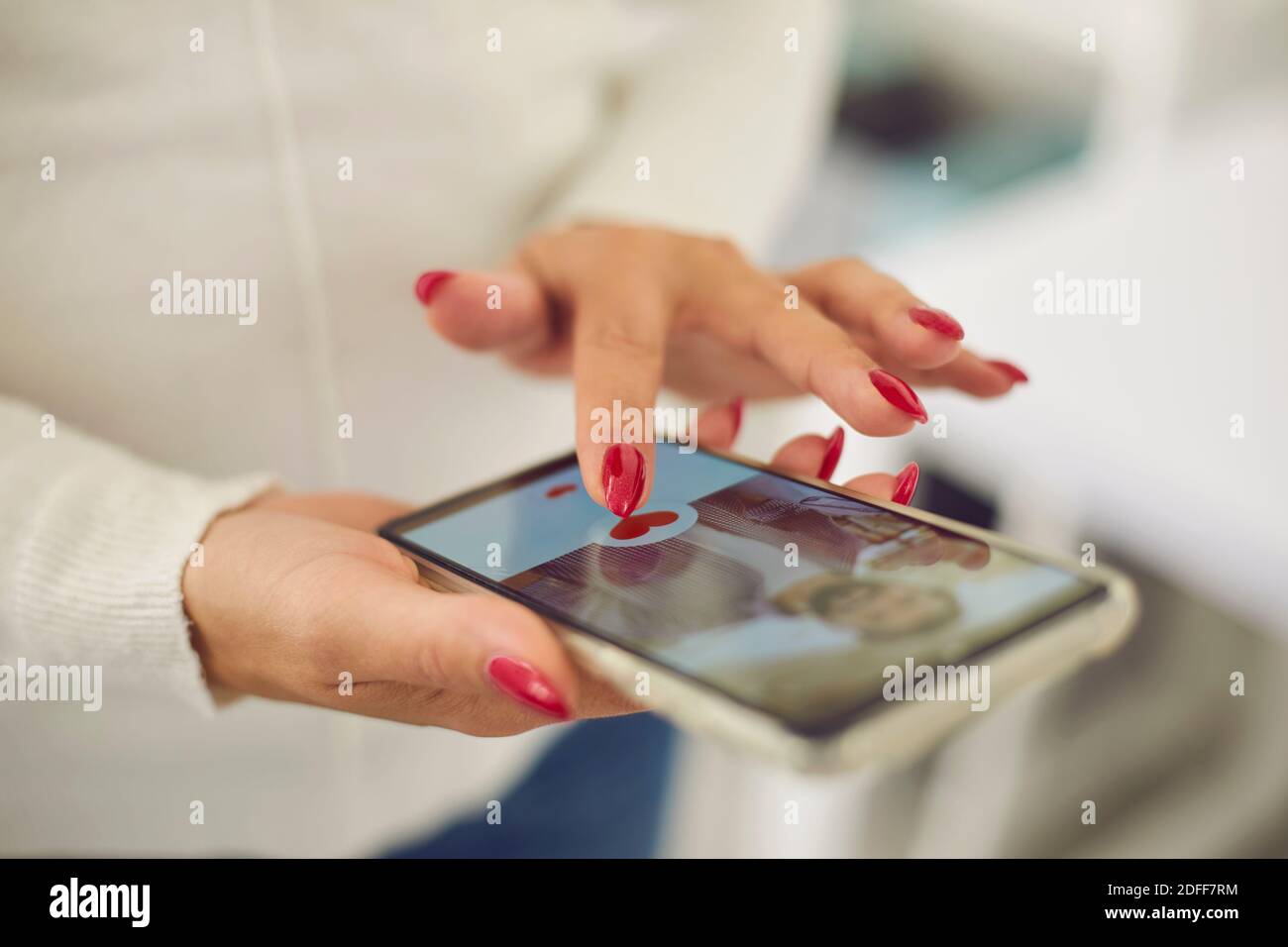 Les mains de jeunes femmes choisissant un petit ami ou un possible mari dans application de rencontres en ligne Banque D'Images