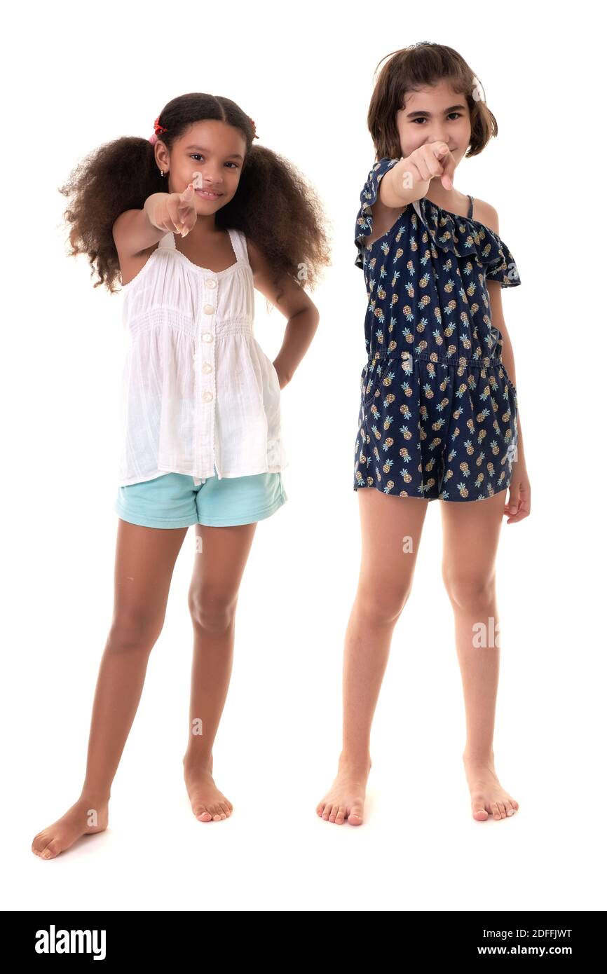 Deux petites filles pointant vers la caméra - hispanique et afro-américain - isolé sur blanc Banque D'Images