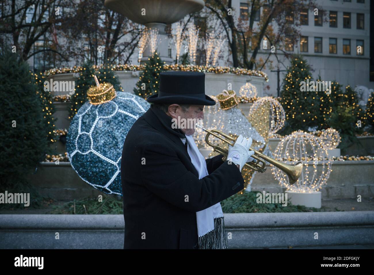 New York. 03 décembre 2020. Le musicien de rue Jacques Letalon interprète des chants de Noël devant la fontaine Pulitzer décorée du Grand Army Plaza. Banque D'Images