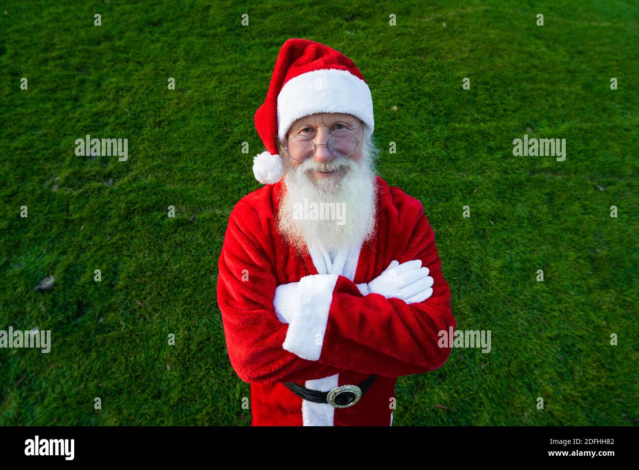 Le portrait en gros plan de l'homme heureux senior en costume du père noël revient à l'appareil photo et sourit. L'humeur du nouvel an. Banque D'Images
