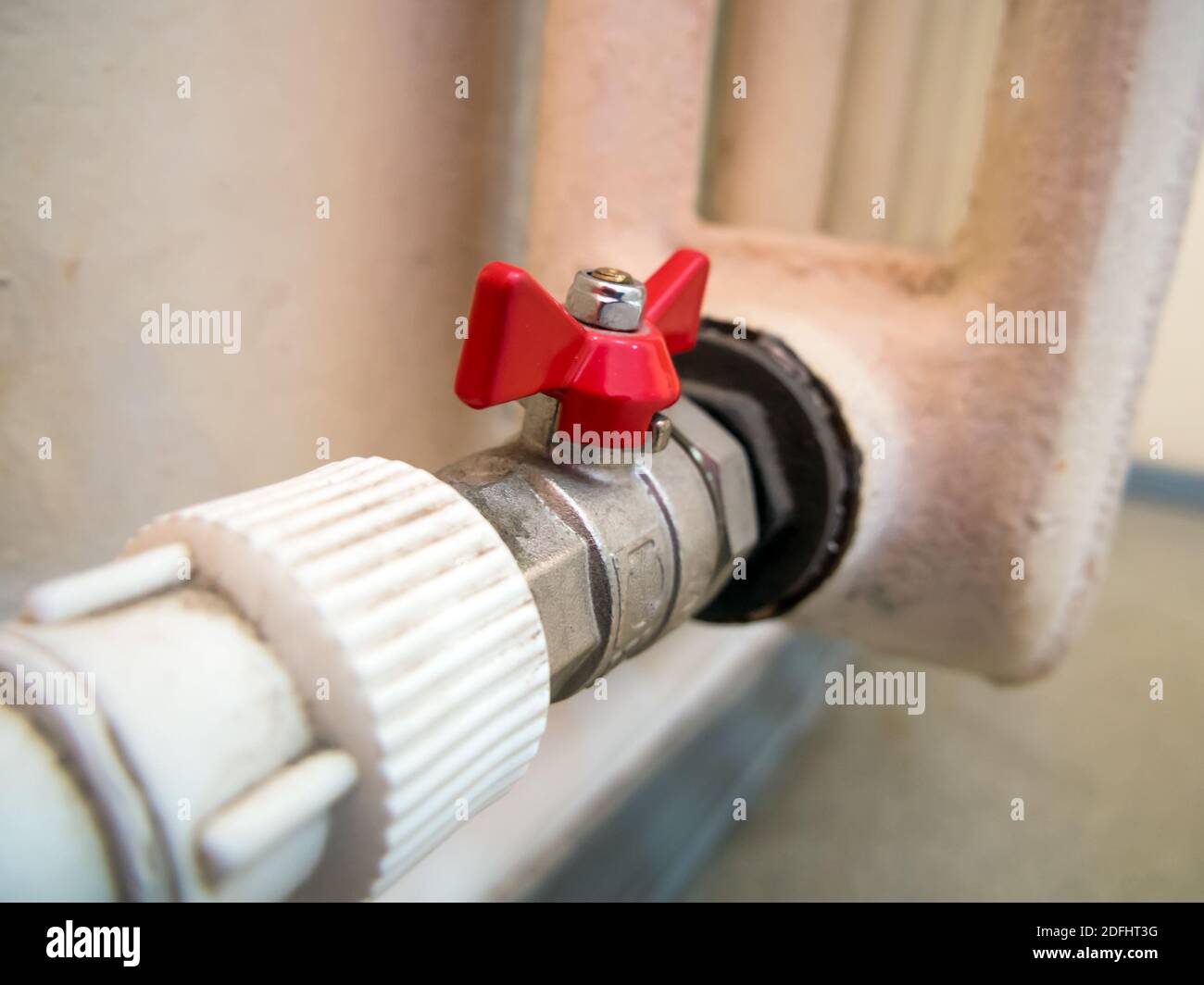 Raccordement d'un ancien radiateur en fonte à des tuyaux en plastique Banque D'Images