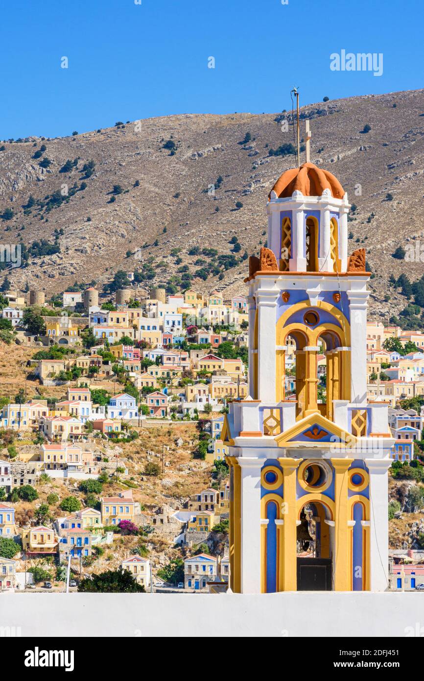 Le clocher de l'église de l'Annonciation avec vue sur le vieux flanc de coteau Horio, l'île Symi, Dodécanèse, Grèce Banque D'Images