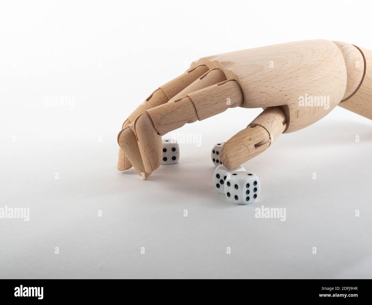 Une main en bois au-dessus d'un tas de dés. Concept sur l'argent et sur le jeu. Banque D'Images