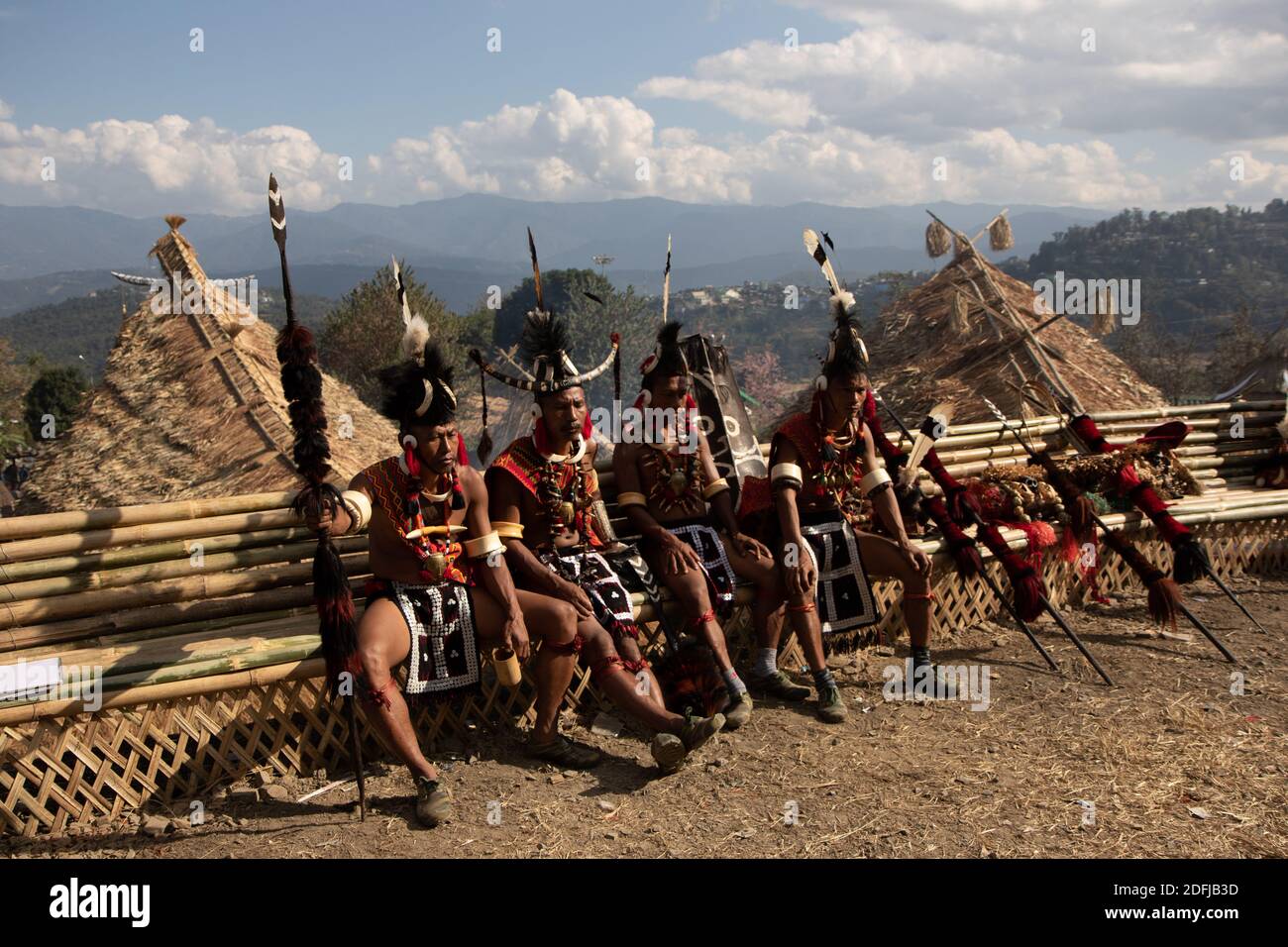 Un groupe de guerriers naga assis avec des armes traditionnelles et Détente dans une cabane traditionnelle de naga au village de Kisama in Nagaland Inde le 2 décembre 2016 Banque D'Images