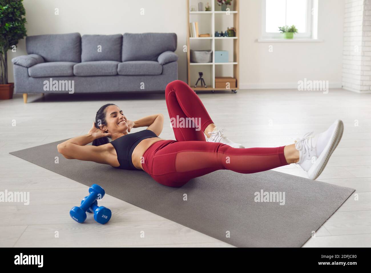 Femme sportive allongé sur un tapis de sport et faisant des croquons de vélo pour activer le muscle et l'entraînement abs. Banque D'Images