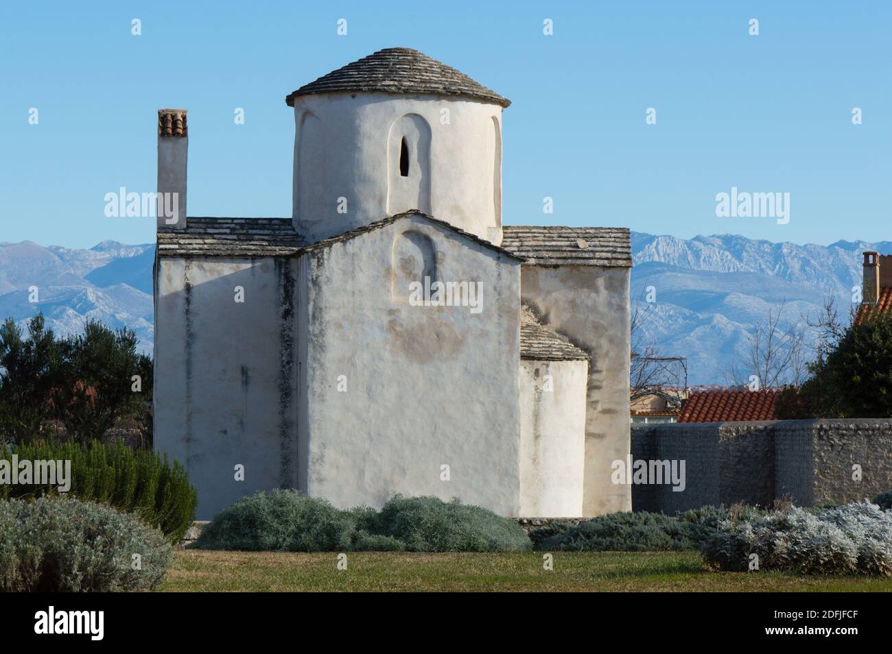 Nin, Croatie - célèbre monument, église de la Sainte-Croix et les montagnes Velebit en arrière-plan; conservé architecture préromane Banque D'Images