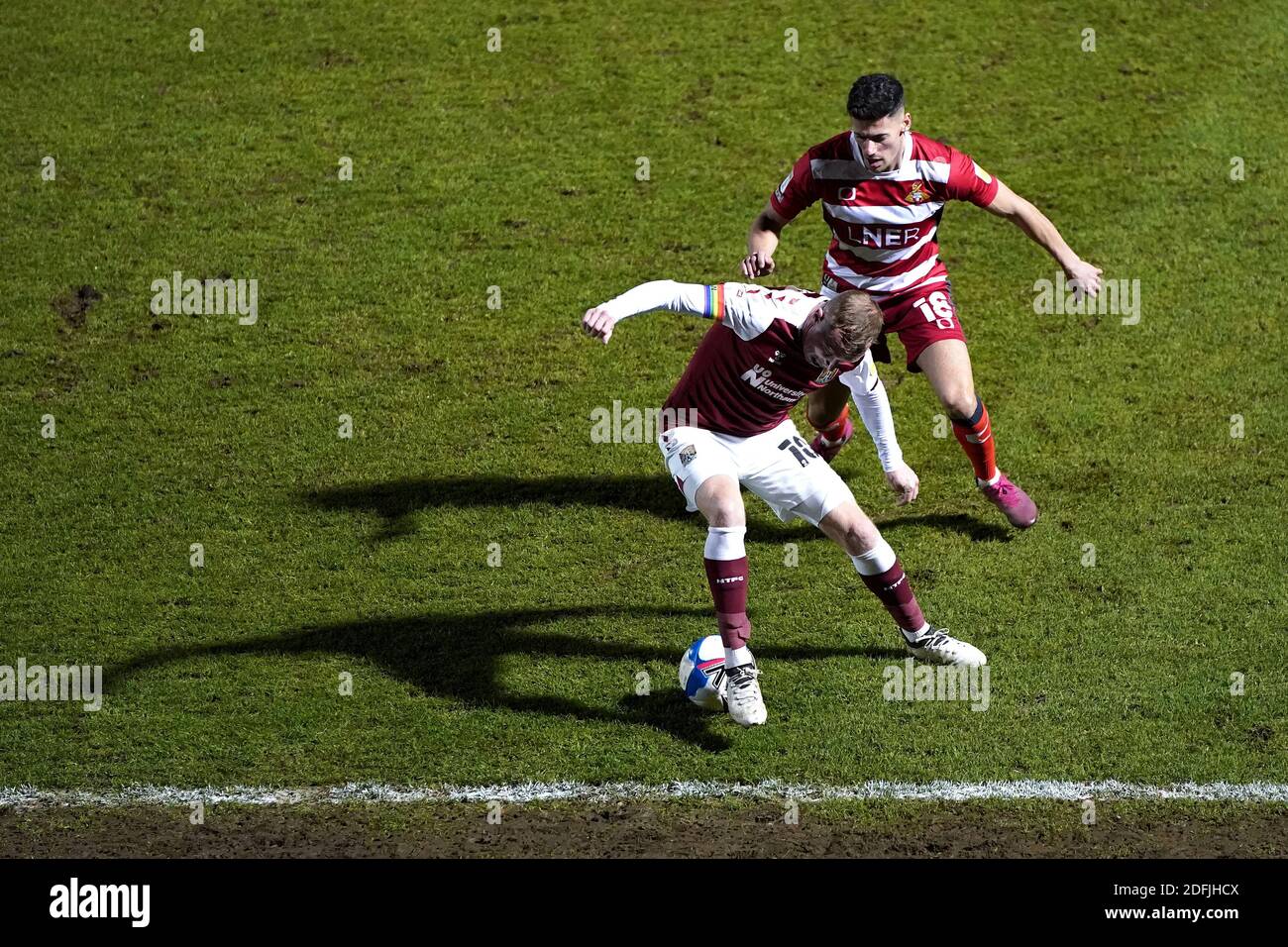 Nicky Adams (devant) de Northampton Town et Ed Williams de Doncaster Rovers se battent pour le ballon lors du match de la Sky Bet League One au PTS Academy Stadium, à Northampton. Banque D'Images