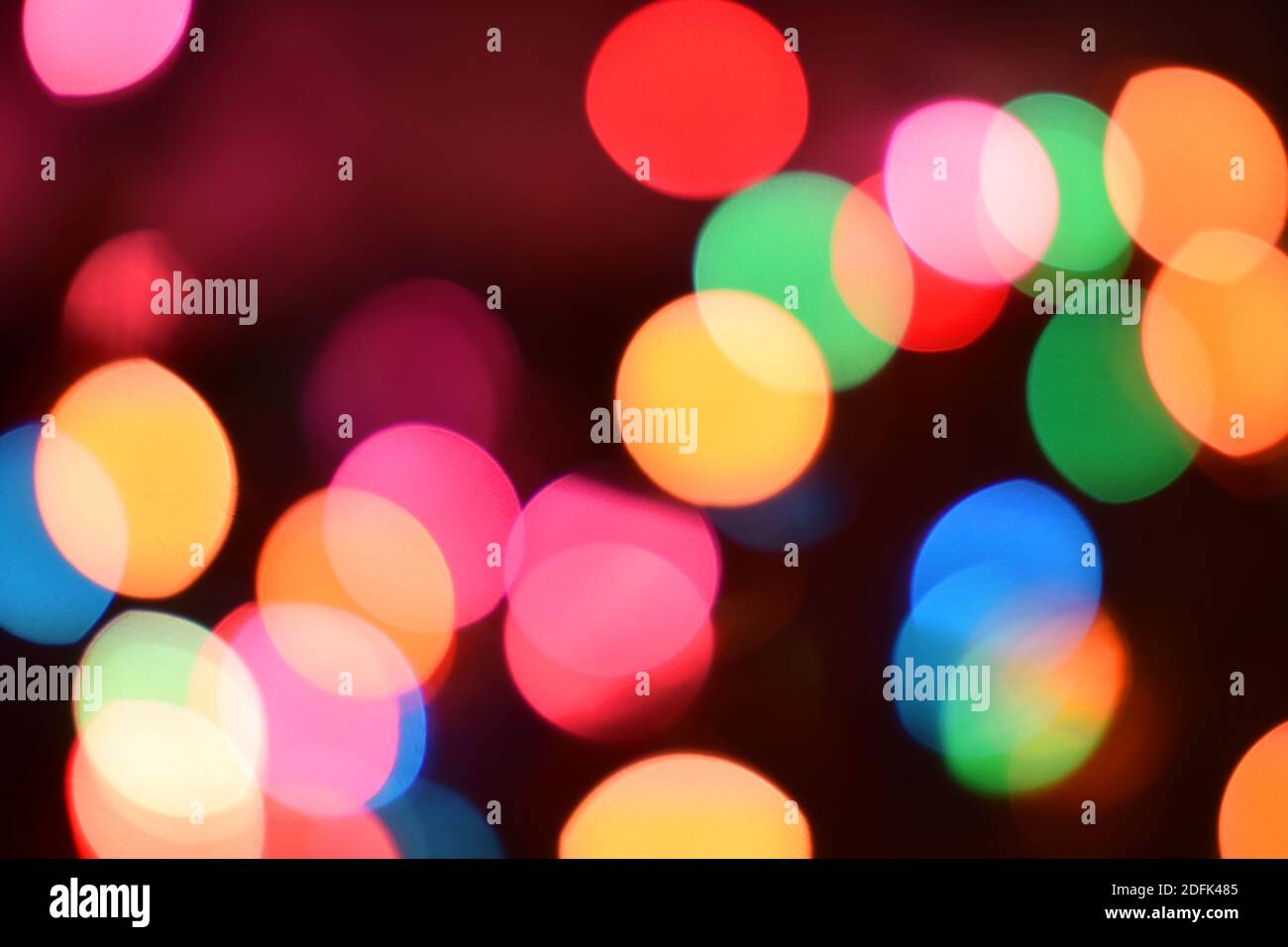 La lumière de couleur rougeoyante et festif créé à partir de cercles de caméra et l'objectif flou. Guirlandes lumineuses de Noël donnant un effet de flou artistique flou. Contexte Banque D'Images